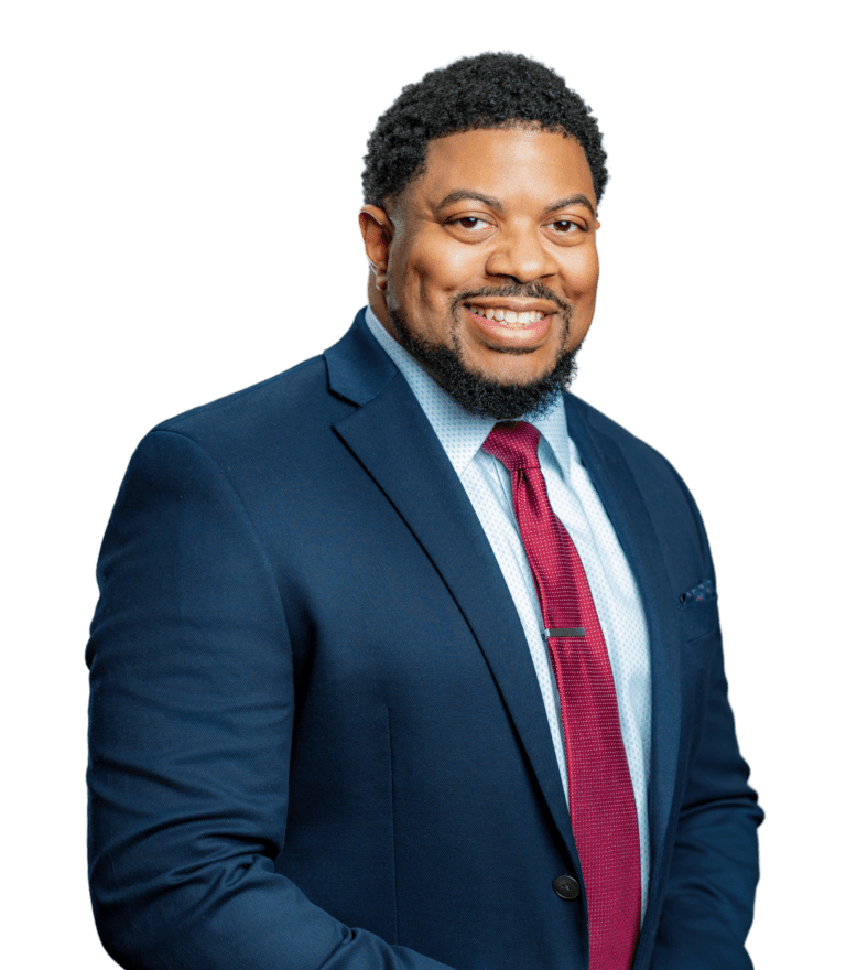 A Black man smiling and wearing a blue suit and burgundy tie.